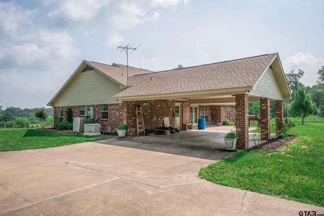 a front view of a house with a garden and patio