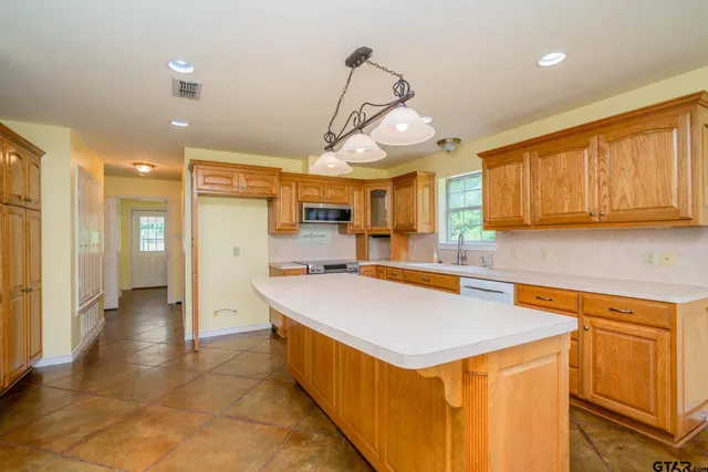a kitchen with stainless steel appliances granite countertop a sink a stove and a refrigerator