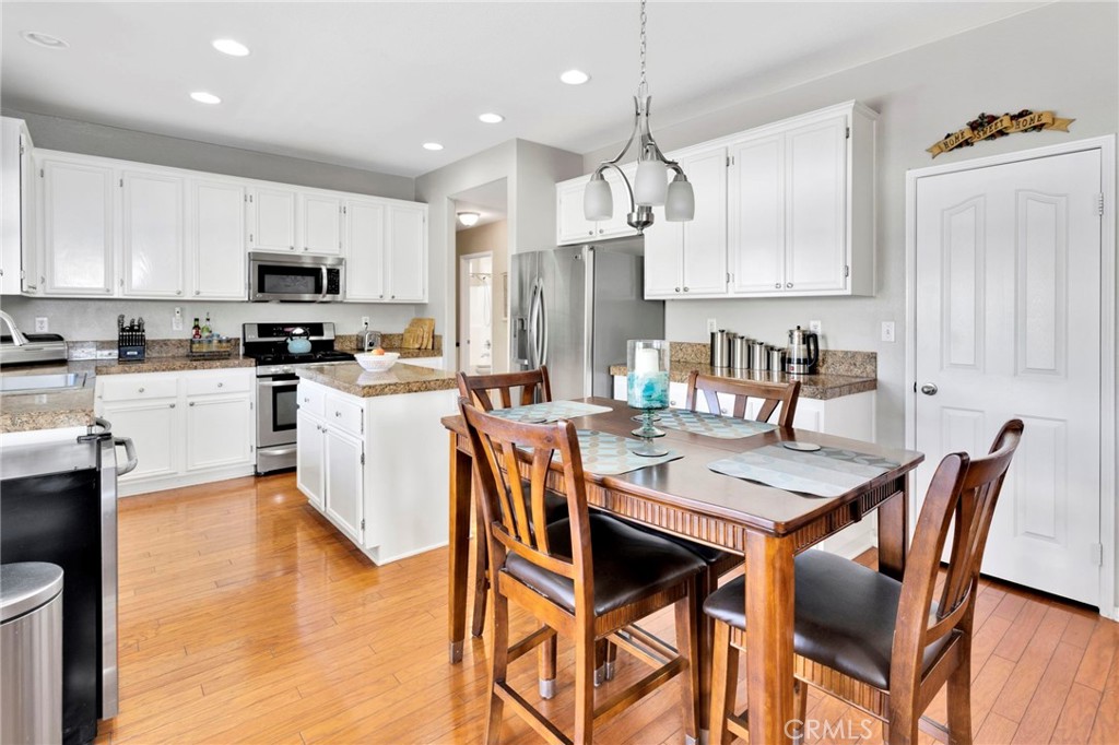 13798 Misty Path Victorville, CA 92392 - Photo 11 of 55 a kitchen with stainless steel appliances granite countertop a stove a sink a dining table and chairs