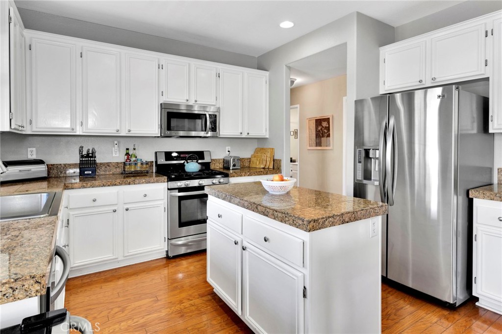 13798 Misty Path Victorville, CA 92392 - Photo 12 of 55 a kitchen with granite countertop white cabinets and stainless steel appliances