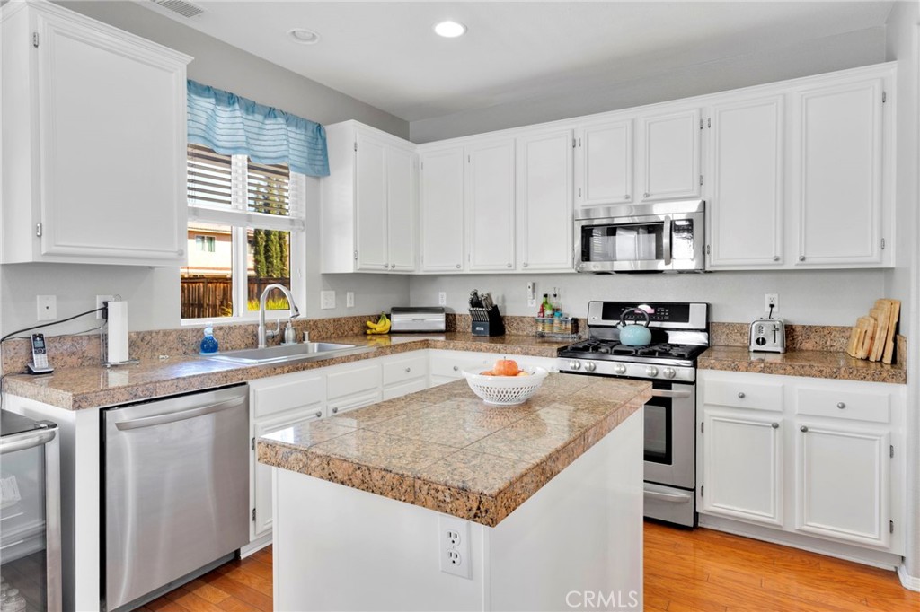 13798 Misty Path Victorville, CA 92392 - Photo 15 of 55 a kitchen with granite countertop a sink a stove and cabinets