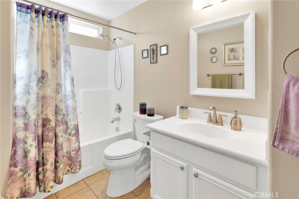13798 Misty Path Victorville, CA 92392 - Photo 22 of 55 a bathroom with a sink a toilet and shower curtain