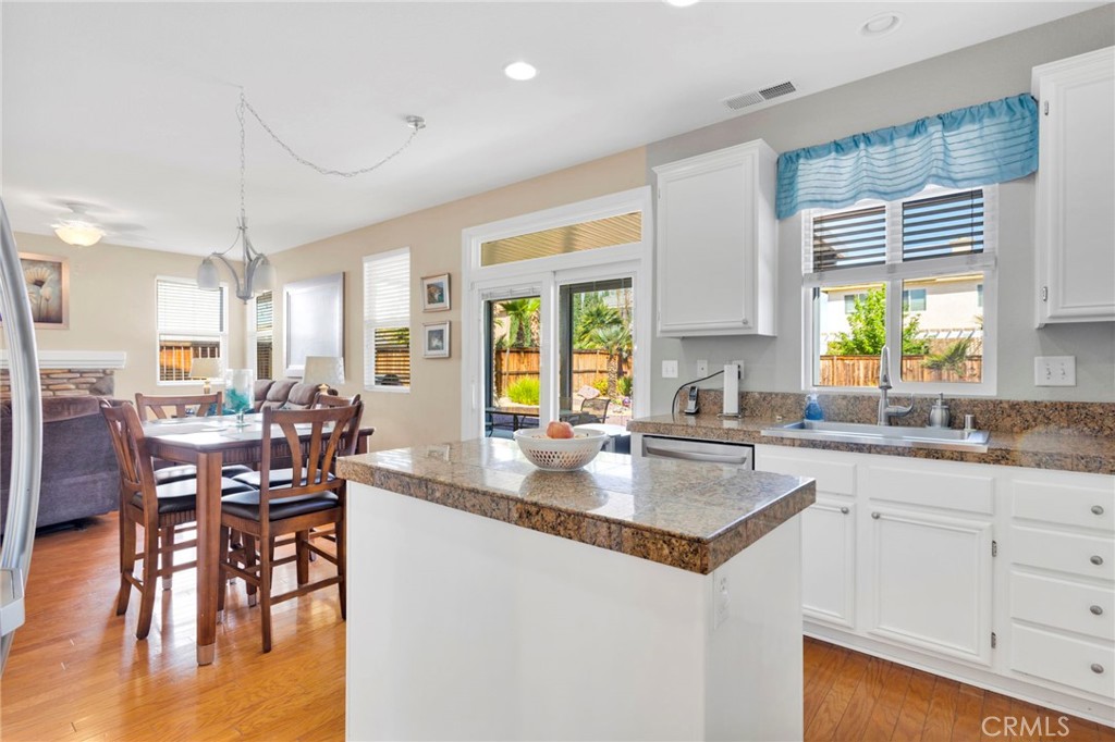 13798 Misty Path Victorville, CA 92392 - Photo 23 of 55 a kitchen with granite countertop a table chairs stove and sink