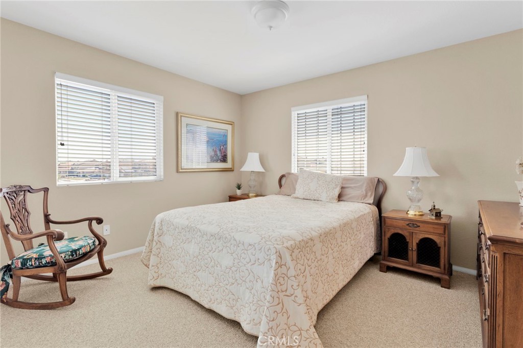 13798 Misty Path Victorville, CA 92392 - Photo 38 of 55 a spacious bedroom with a bed a chair and next to a window