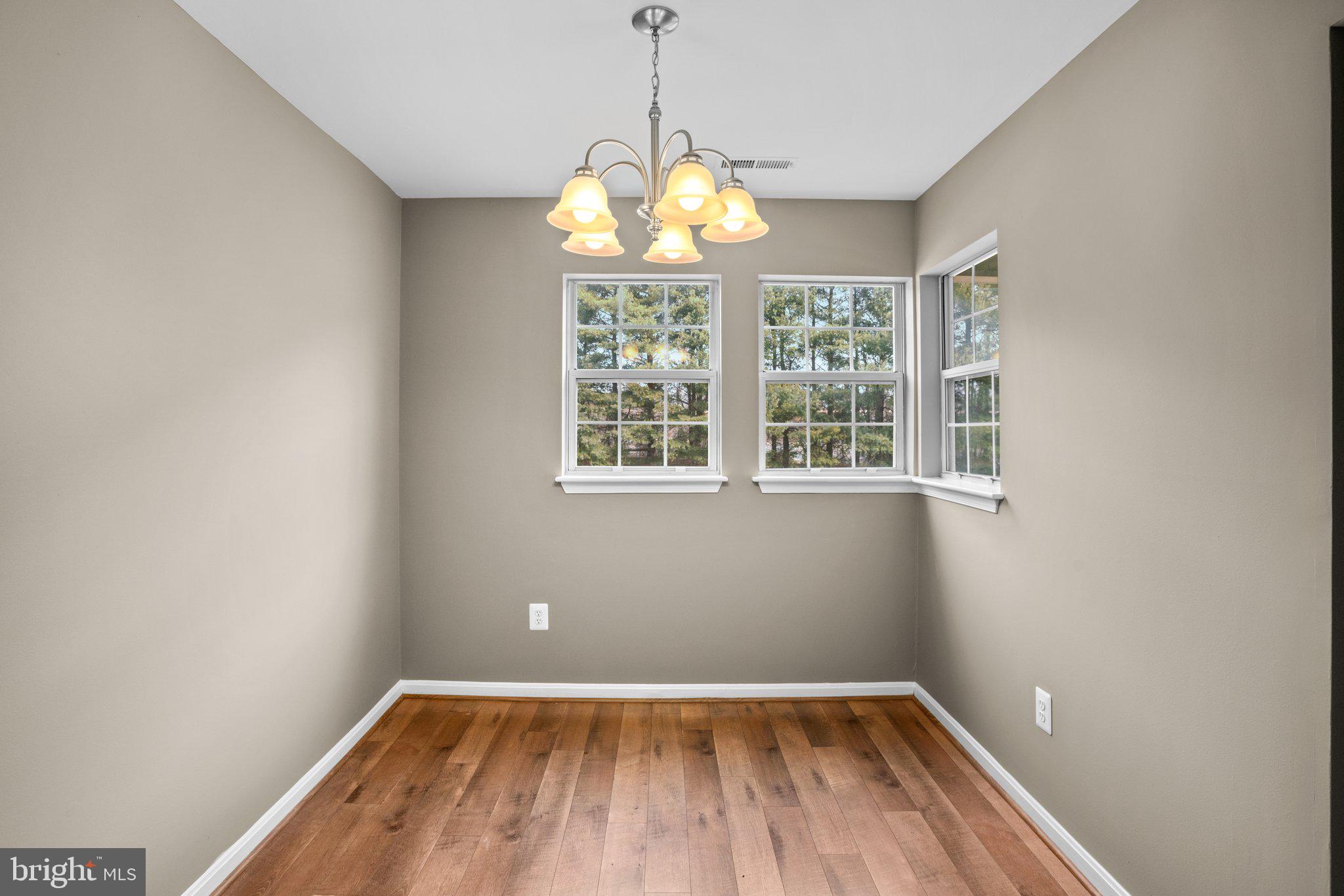 8335 Montgomery Run Road, Unit K Ellicott City, MD 21043 - Photo 11 of 42 a view of an empty room with wooden floor and a window