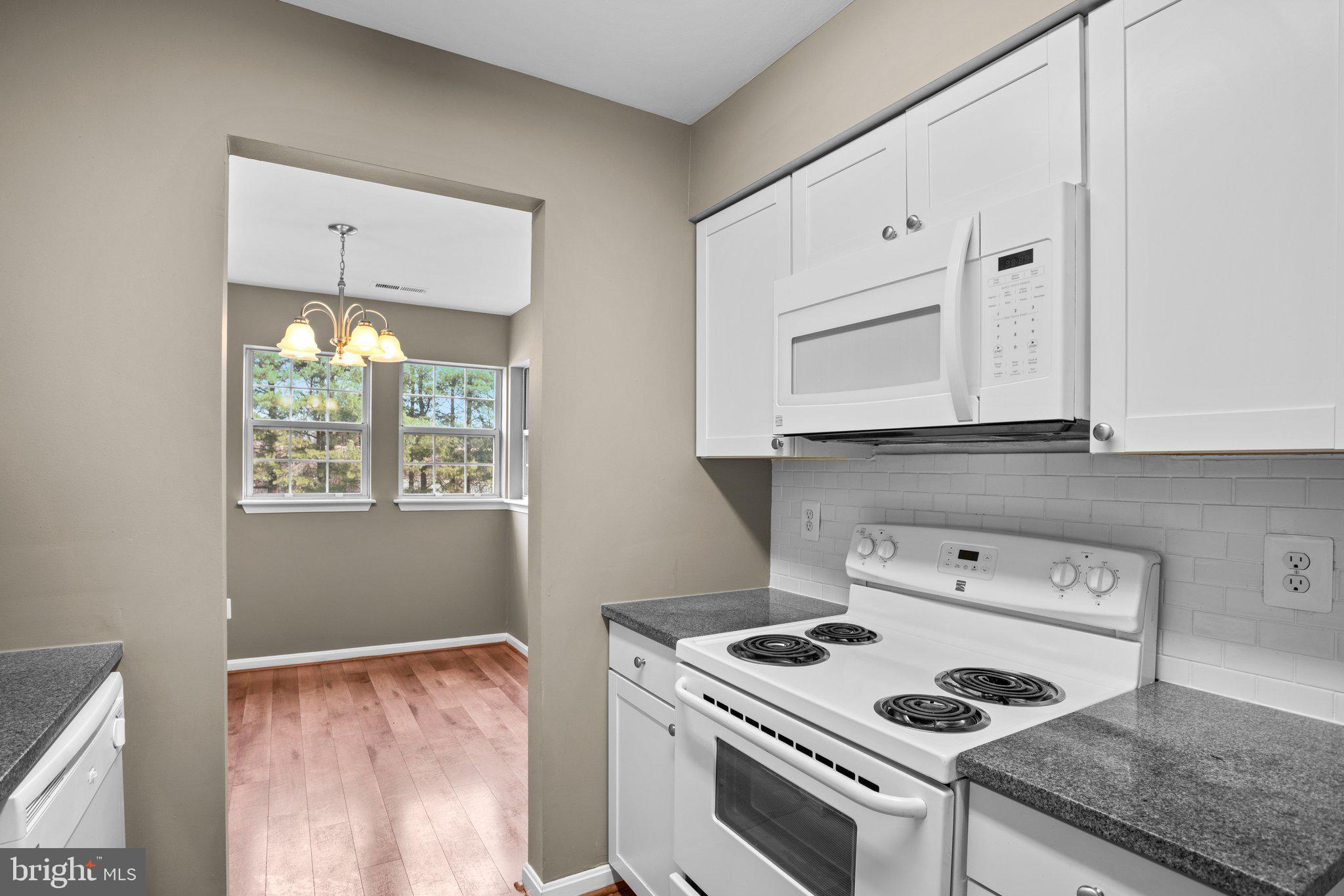 8335 Montgomery Run Road, Unit K Ellicott City, MD 21043 - Photo 15 of 42 a kitchen with a stove and white cabinets