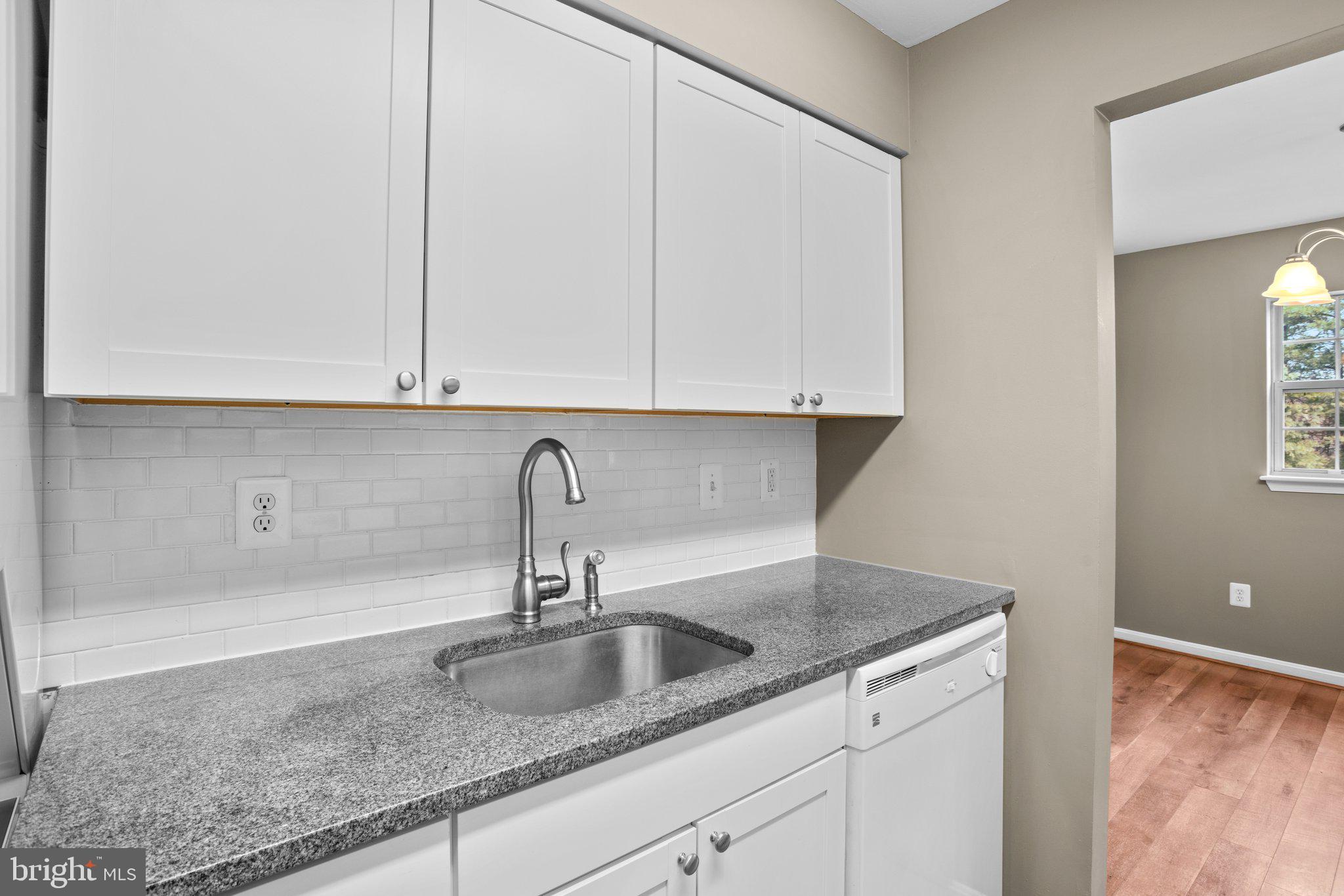 8335 Montgomery Run Road, Unit K Ellicott City, MD 21043 - Photo 16 of 42 a kitchen with granite countertop a sink and cabinets