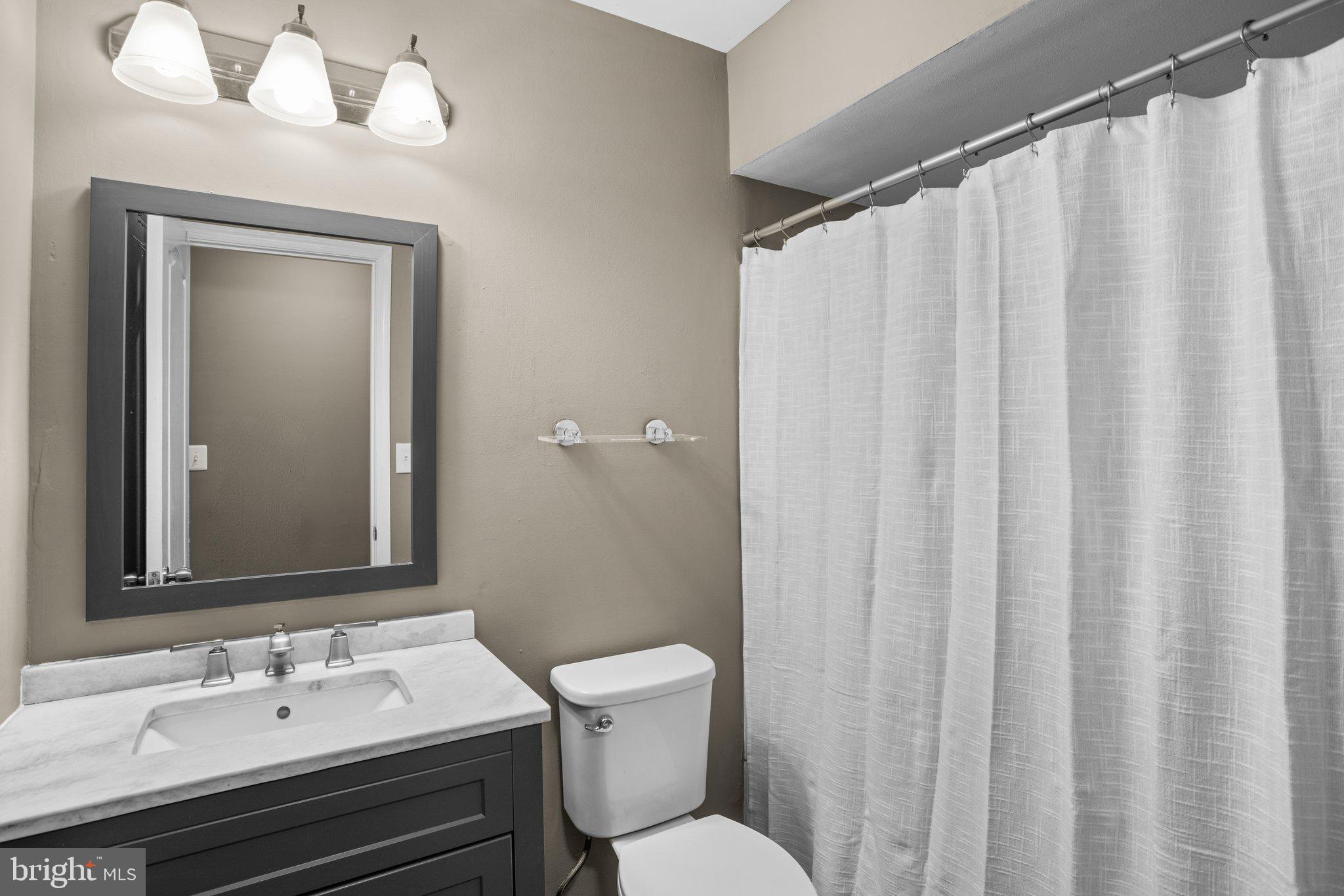 8335 Montgomery Run Road, Unit K Ellicott City, MD 21043 - Photo 38 of 42 a bathroom with a sink a toilet and shower curtain