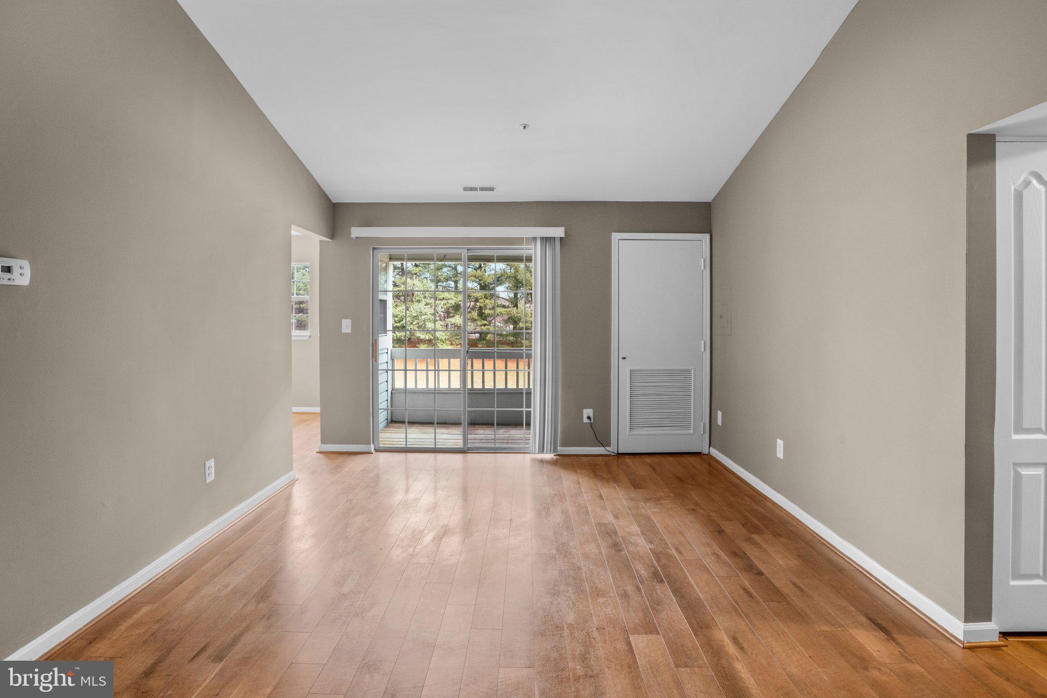 8335 Montgomery Run Road, Unit K Ellicott City, MD 21043 - Photo 5 of 42 a view of an empty room with wooden floor and a window