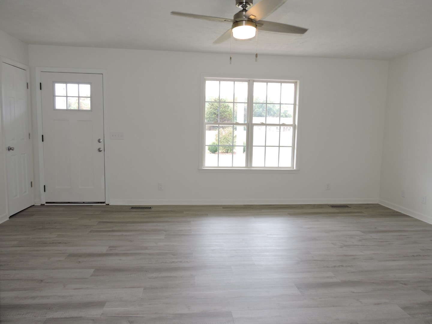 118 Ferrells Loop Road Manchester, TN 37355 - Photo 9 of 28 an empty room with wooden floor cabinet and windows
