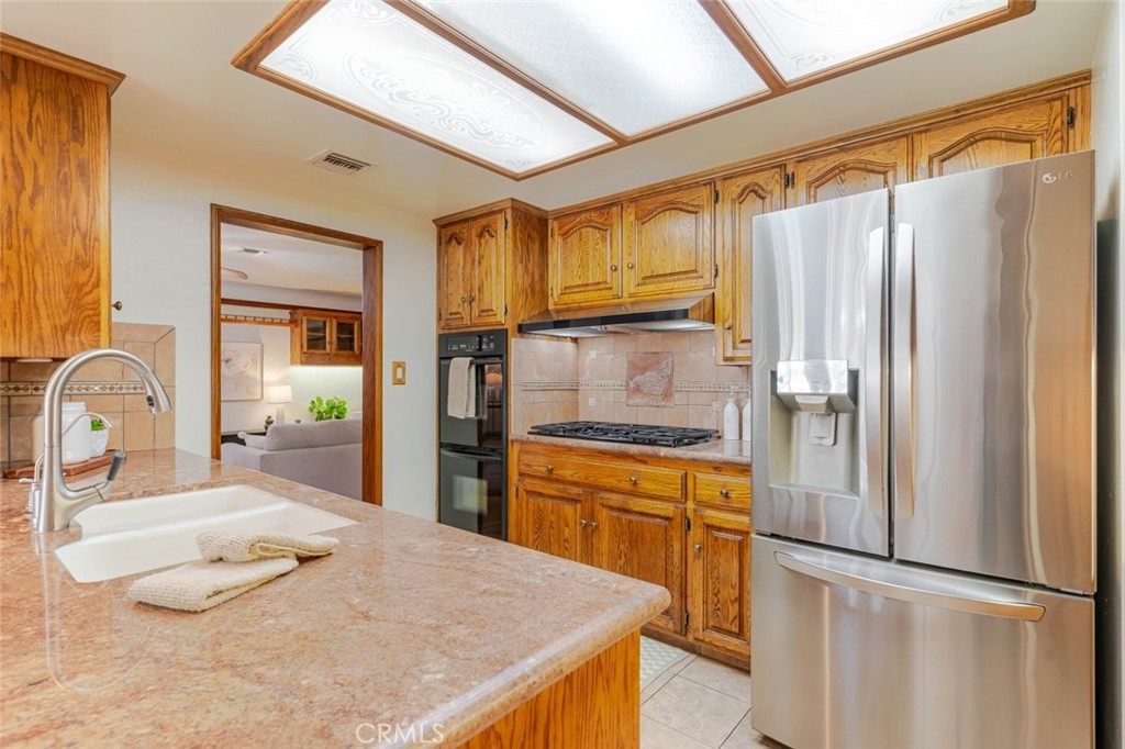 835 North Lincoln Street Burbank, CA 91506 - Photo 22 of 38 a kitchen with stainless steel appliances granite countertop a refrigerator a sink and white cabinets