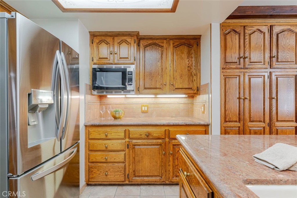 835 North Lincoln Street Burbank, CA 91506 - Photo 26 of 38 a kitchen with stainless steel appliances granite countertop a refrigerator a stove and wooden cabinets with wooden floor