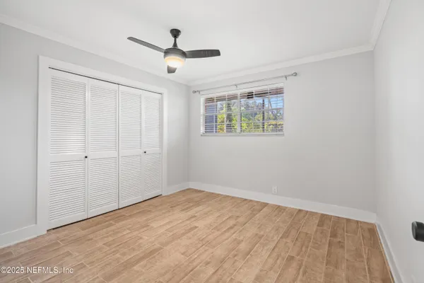 a view of empty room with wooden floor