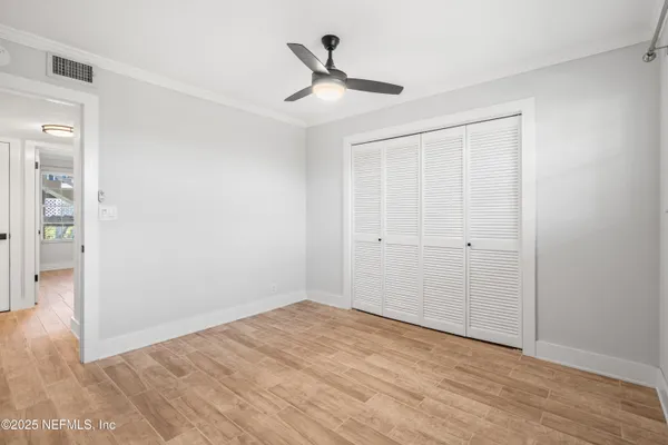 a view of empty room with wooden floor