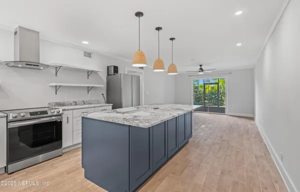 a kitchen with a stove and a wooden floor