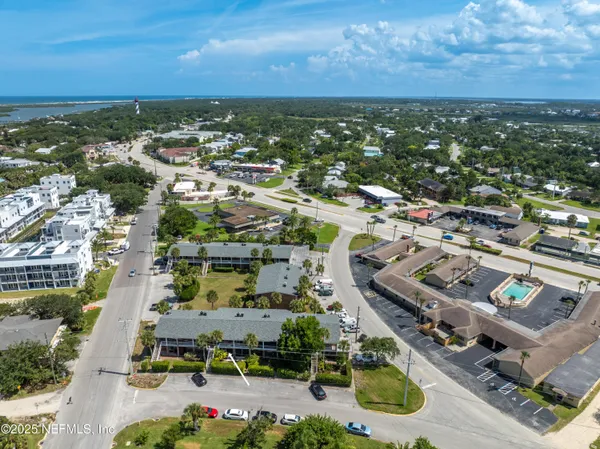 an aerial view of a city with lots of residential buildings and ocean view in back