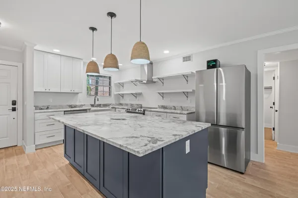 a kitchen with stainless steel appliances granite countertop a sink a refrigerator and a stove