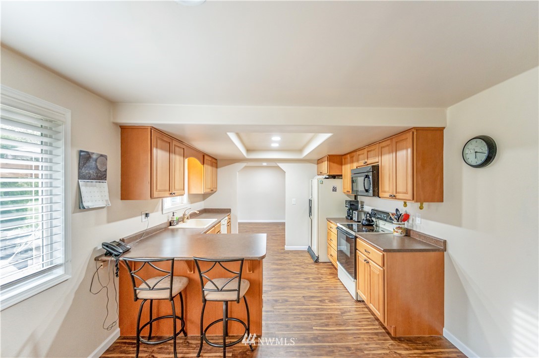 6891 Old Guide Road Lynden, WA 98264 - Photo 11 of 32 a kitchen with stainless steel appliances kitchen island granite countertop a stove a sink and a refrigerator