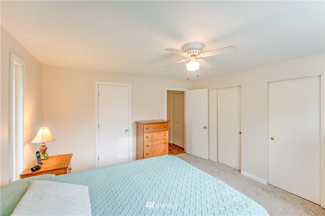 6891 Old Guide Road Lynden, WA 98264 - Photo 23 of 32 a bedroom with a bed and a chandelier