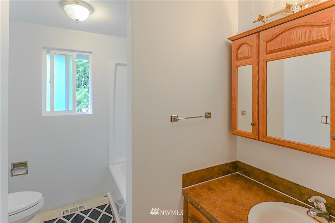 6891 Old Guide Road Lynden, WA 98264 - Photo 25 of 32 a bathroom with a granite countertop sink mirror vanity and toilet
