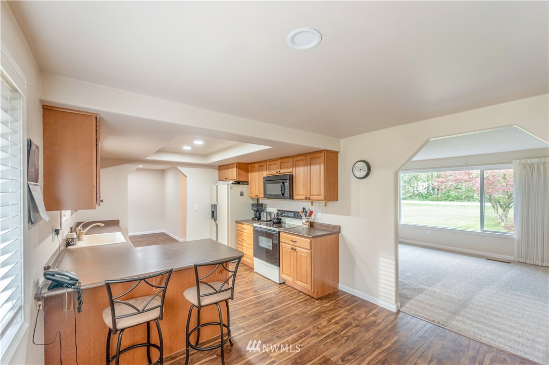 6891 Old Guide Road Lynden, WA 98264 - Photo 10 of 32 a kitchen with stainless steel appliances kitchen island granite countertop a sink and cabinets