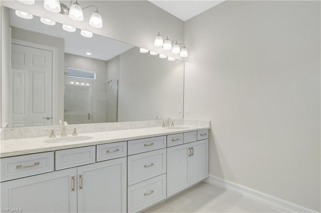 335 Tamarindo Lane Naples, FL 34114 - Photo 13 of 38 a bathroom with a sink vanity and a mirror