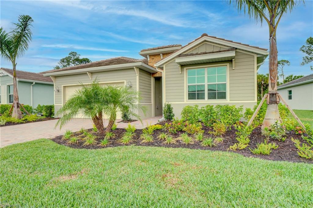 335 Tamarindo Lane Naples, FL 34114 - Photo 2 of 38 a front view of a house with a yard and potted plants