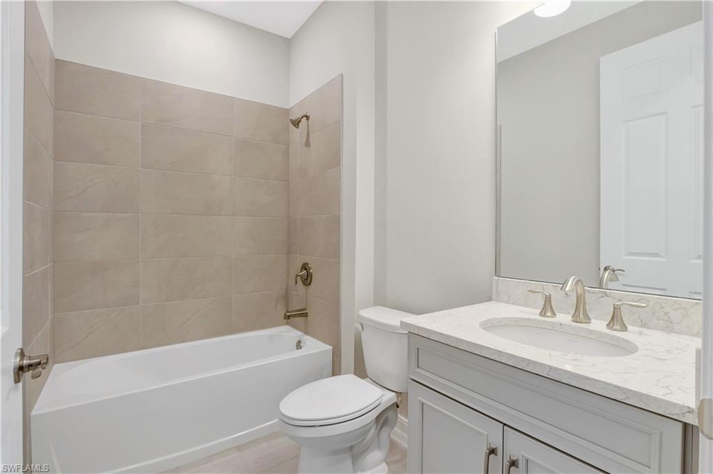 335 Tamarindo Lane Naples, FL 34114 - Photo 21 of 38 a bathroom with a granite countertop sink a toilet and a bathtub