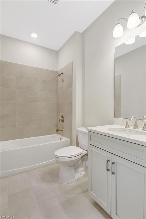 335 Tamarindo Lane Naples, FL 34114 - Photo 22 of 38 a bathroom with a toilet a sink a mirror a bathtub and vanity