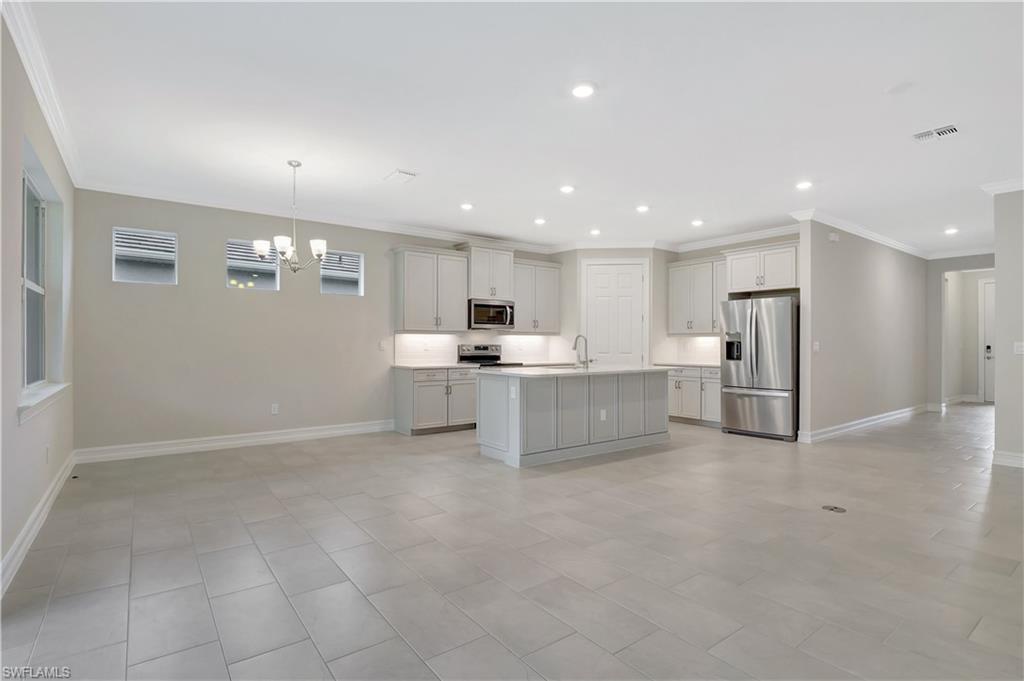 335 Tamarindo Lane Naples, FL 34114 - Photo 7 of 38 a view of kitchen with kitchen island a sink stainless steel appliances and cabinets