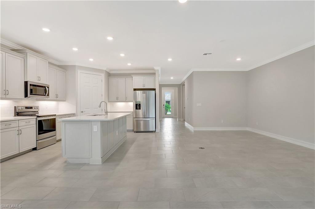 335 Tamarindo Lane Naples, FL 34114 - Photo 8 of 38 a large kitchen with a large counter top stainless steel appliances and cabinets