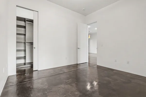 an empty room with closet and entryway