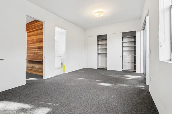 a view of an empty room with cabinet and a window