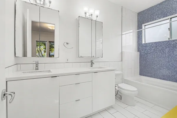 a bathroom with a toilet a sink a mirror a bathtub and vanity