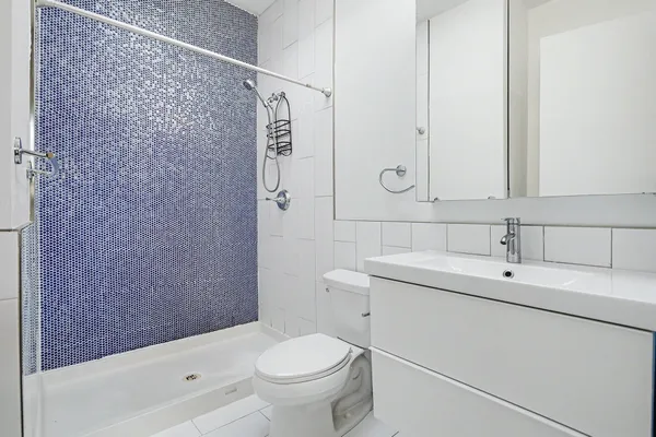 a bathroom with a sink a toilet and shower