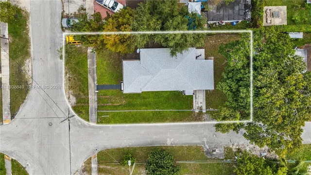 an aerial view of residential houses with outdoor space and trees