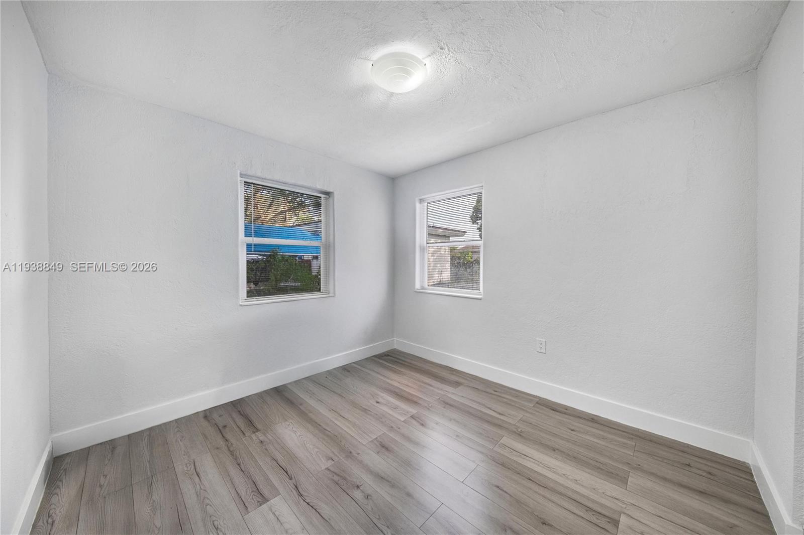 1244 Northwest 45th Street Miami, FL 33142 - Photo 10 of 23 wooden floor in an empty room with a window