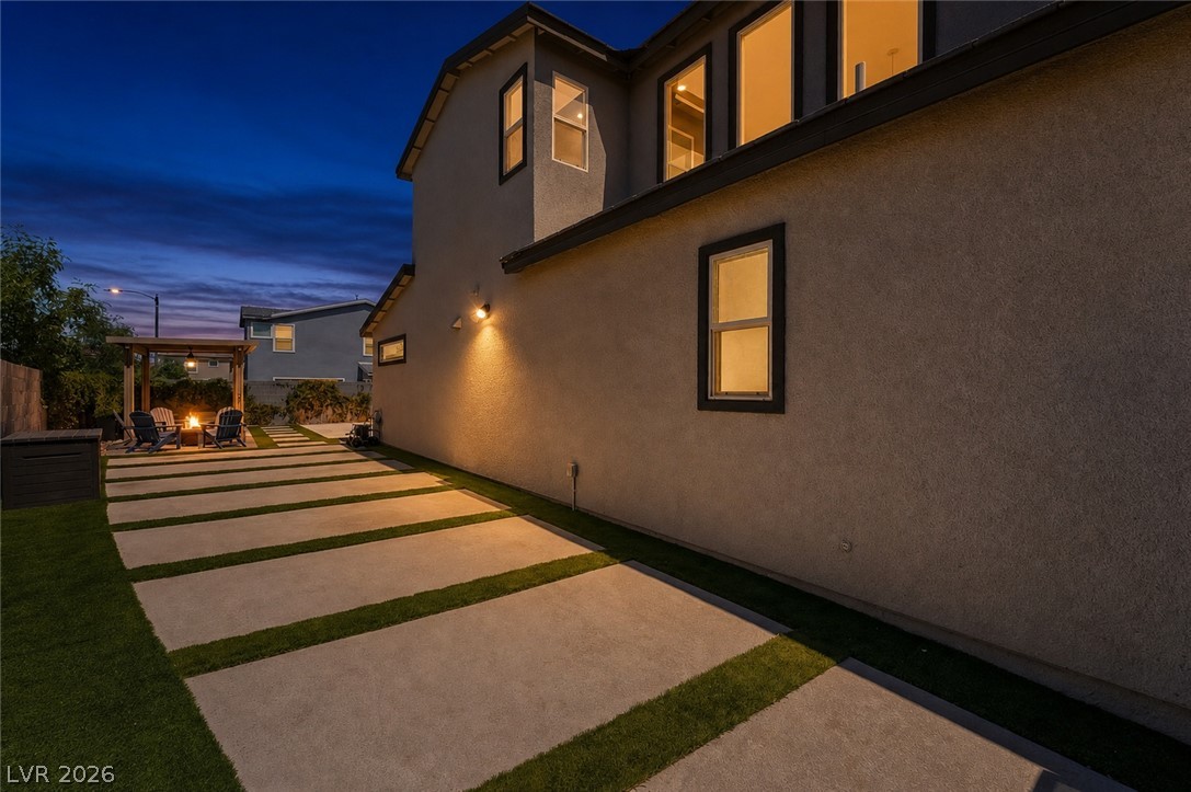 2166 Trivero Street Henderson, NV 89044 - Photo 55 of 61 An inviting backyard patio with a fire pit offers a serene evening retreat.