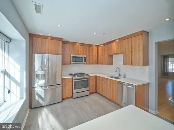 a kitchen with white cabinets and stainless steel appliances