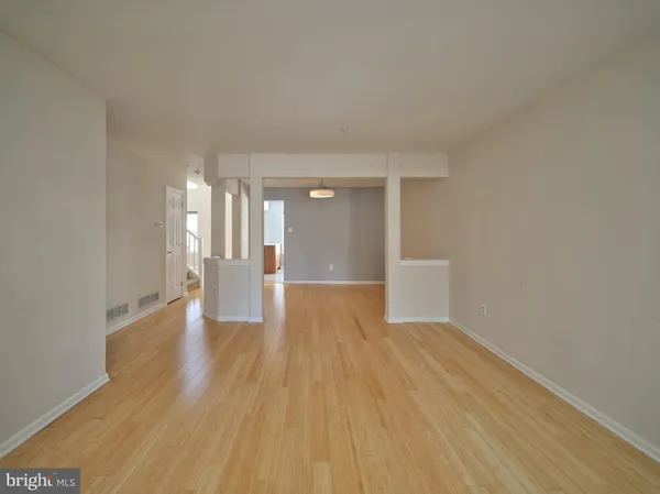 a view of a big room with wooden floor and windows