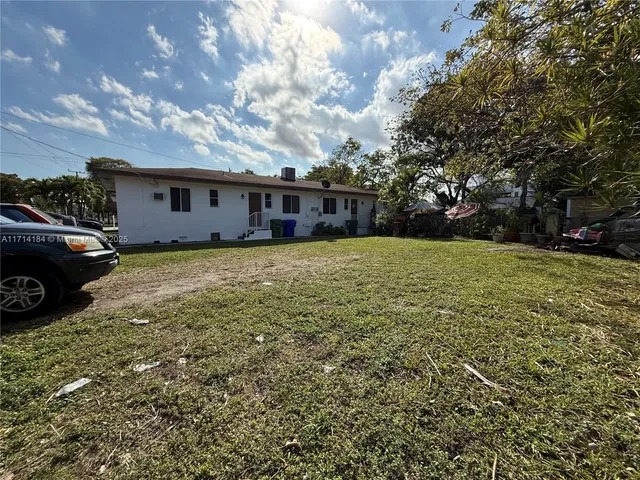 a view of a house with a big yard and a large tree