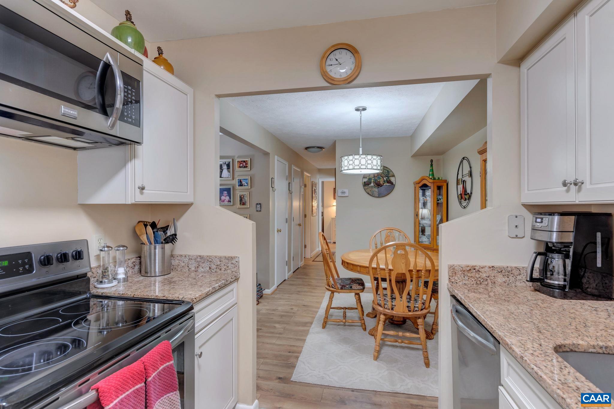 114 Turtle Creek Road, Unit 1 Charlottesville, VA 22901 - Photo 11 of 24 a kitchen with stainless steel appliances granite countertop a stove top oven a sink a dining table and chairs with wooden floor