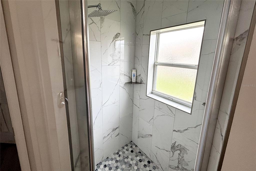 9182 Tarleton Circle Weeki Wachee, FL 34613 - Photo 13 of 23 a bathroom with a window toilet and a shower