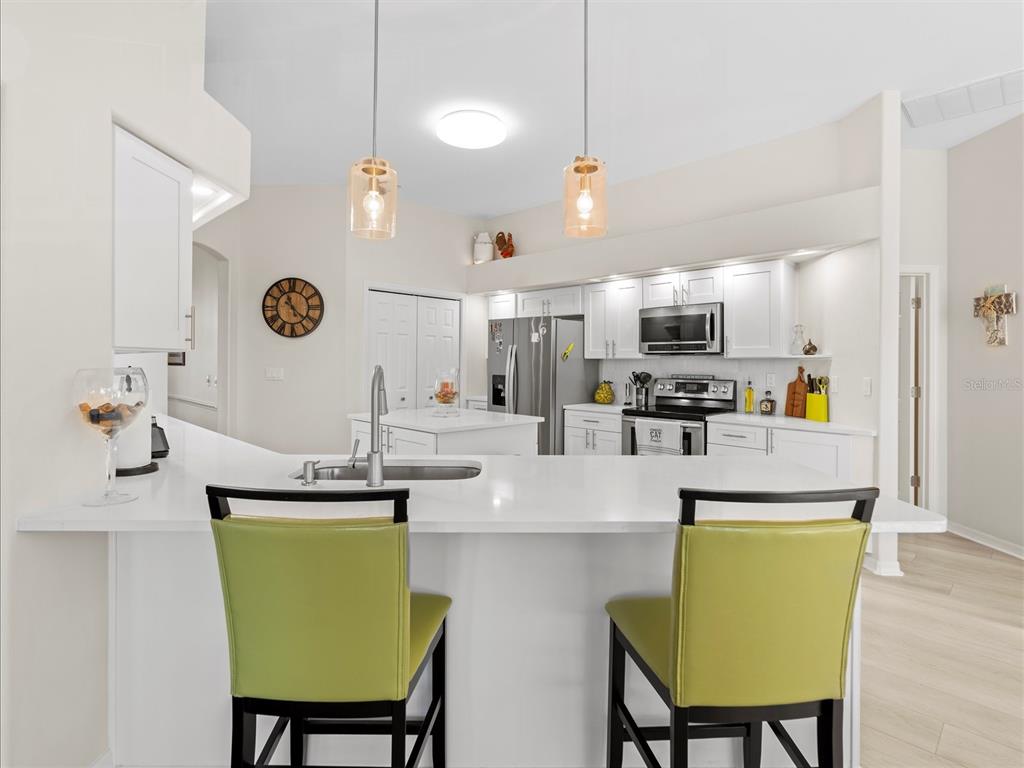9182 Tarleton Circle Weeki Wachee, FL 34613 - Photo 7 of 23 a kitchen with kitchen island white cabinets and stainless steel appliances