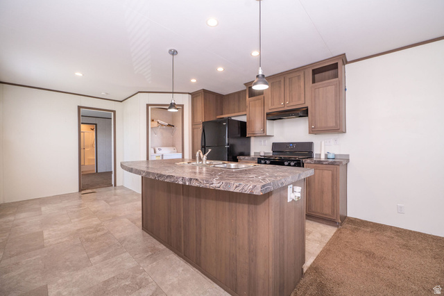2491 Highway 89, Unit 403 Pleasant View, UT 84404 - Photo 7 of 32 Kitchen featuring a central island with an integrated sink, wood-finish cabinetry, black appliances, and pendant lighting