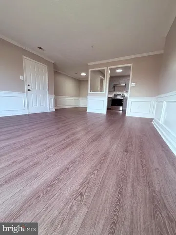 a view of empty room with a fireplace and wooden floor