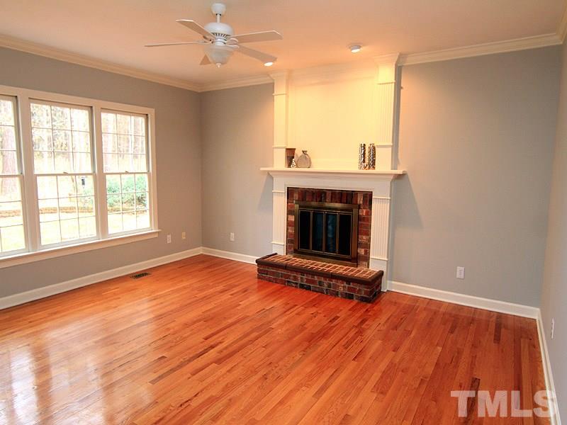 7023 Spring Ridge Road Cary, NC 27518 - Photo 6 of 12 Plenty of windows and site finished hardwood floors in this family room with wood burning fireplace.