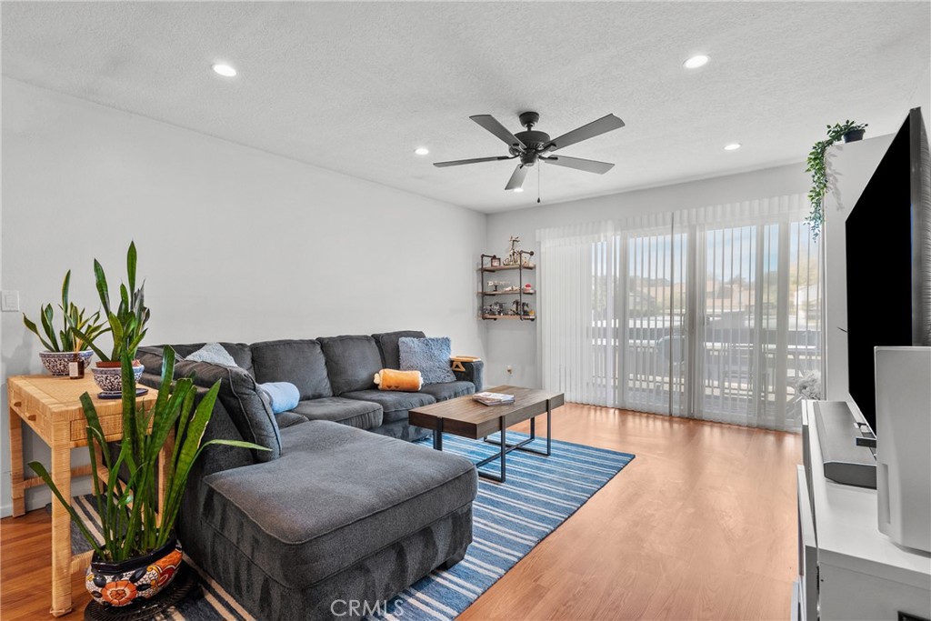 25736 Player Drive, Unit R4 Valencia, CA 91355 - Photo 2 of 50 a living room with furniture a flat screen tv and a floor to ceiling window
