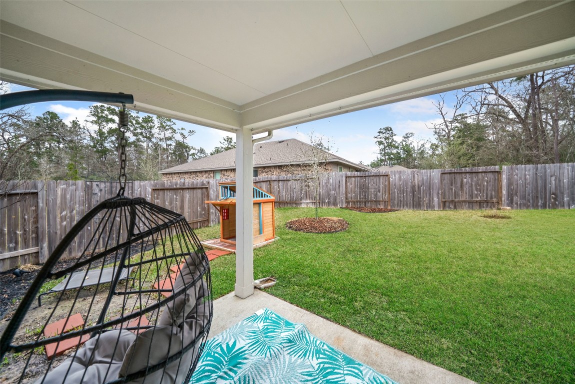 3308 Cold Swan Court Conroe, TX 77301 - Photo 23 of 25 Enjoy the covered patio.
(*Chair & playset not included.)