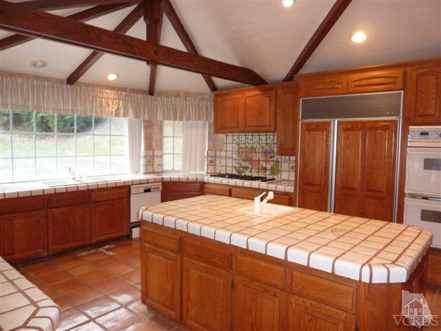 51 Buckskin Road Bell Canyon, CA 91307 - Photo 6 of 24 a large kitchen with kitchen island a large window a sink and stainless steel appliances